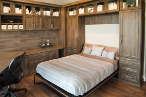 Made up murphy bed surrounded by wood shelving 