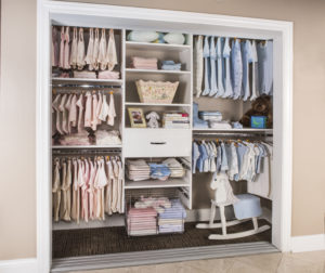 Reach-in closet with shelving and pink and blue kids clothings